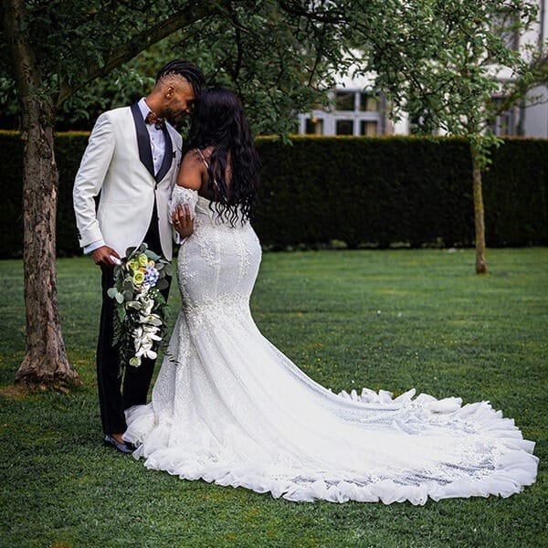 young-bride-and-groom-taking-wedding-photos-in-the-garden-with-her-wedding-gown