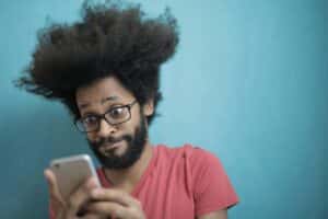 african-man-surprised-by-news-on-his-phone-wedding-vendor-cancellation