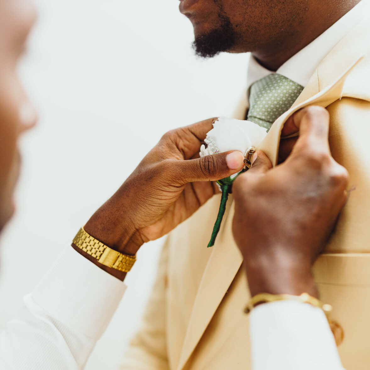 best-man-helping-the-groom-fix-his-suit-and-tie-in-a-well-lit-room