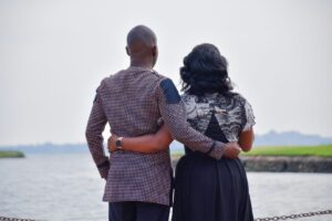 young-ugandan-engaged-couple-holding-each-other-looking-at-the-lake-during-the-day